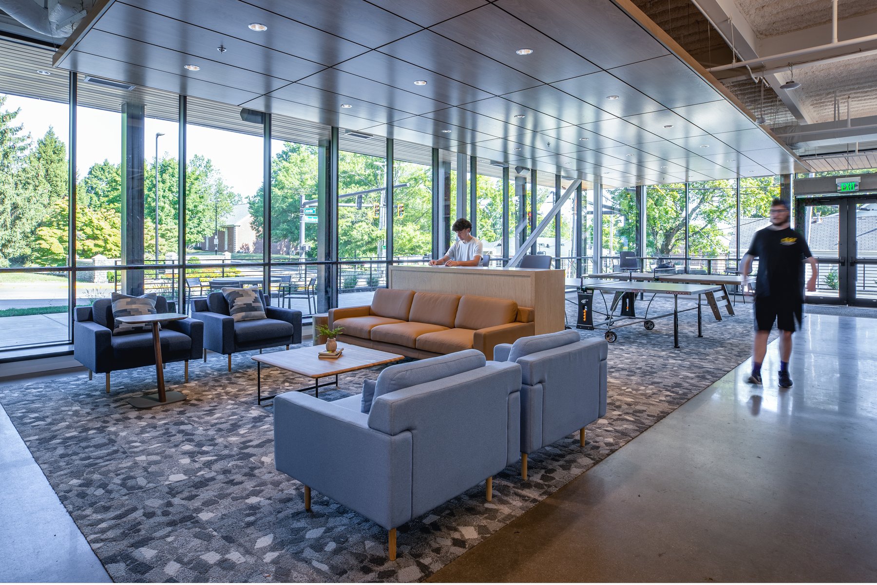 Kentucky University — welcome lounge with blue and tan sofas, a reception desk, and a ping-pong table