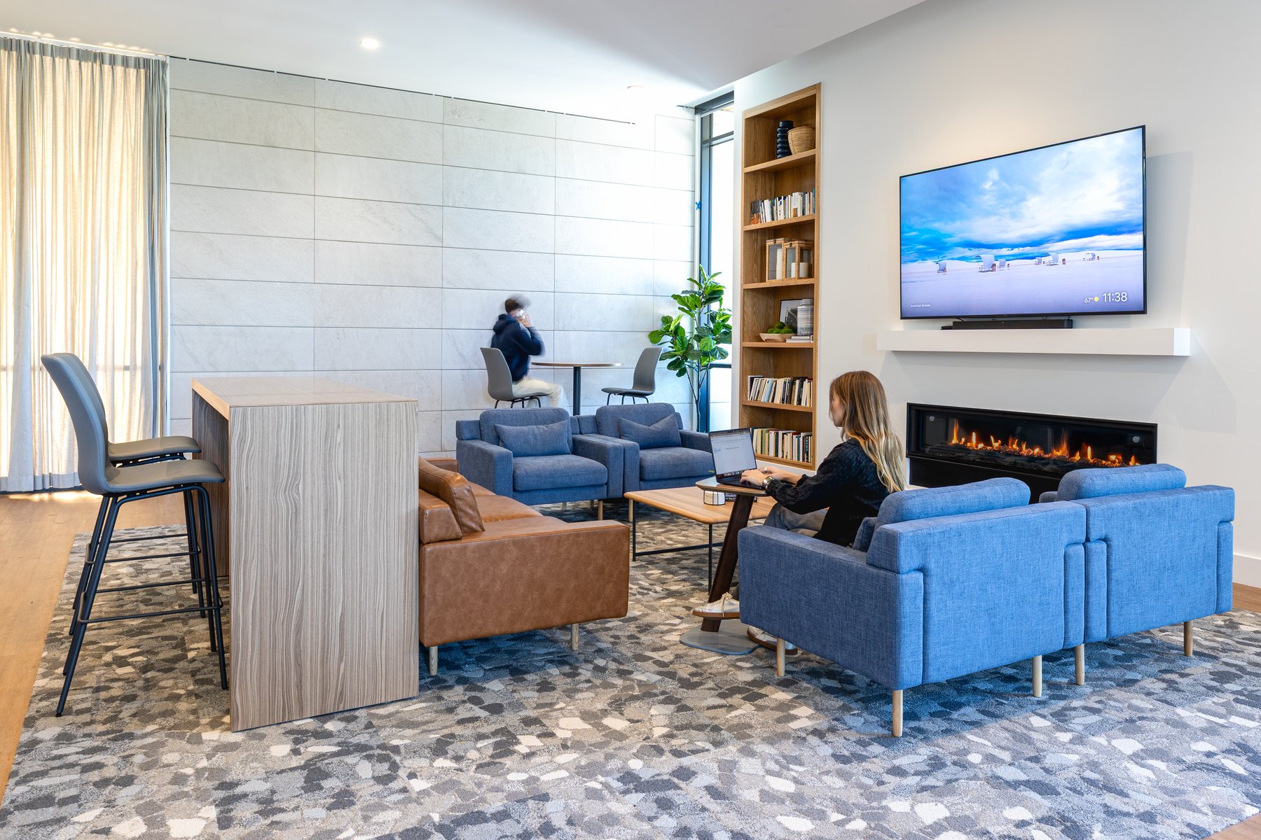 Kentucky University — fireside lounge with tan and blue seating around the fireplace